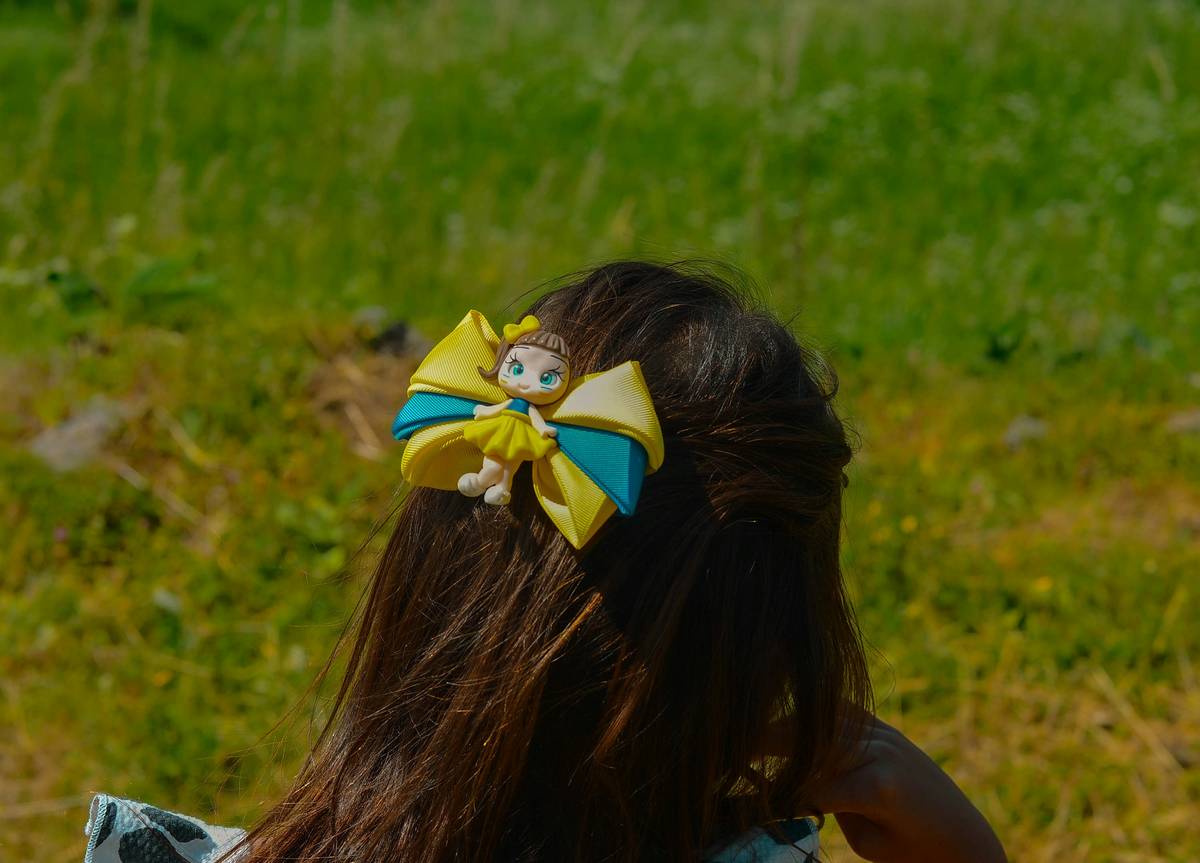 Woman achieving Professional Finish with gold hair barrette at occipital bone placement