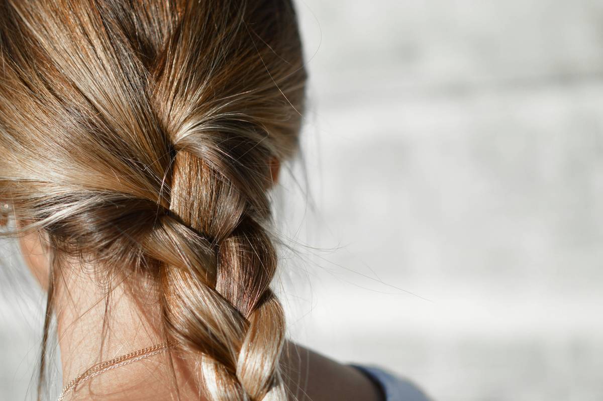 Woman using hair barrettes for Quick Fixes on messy morning hair