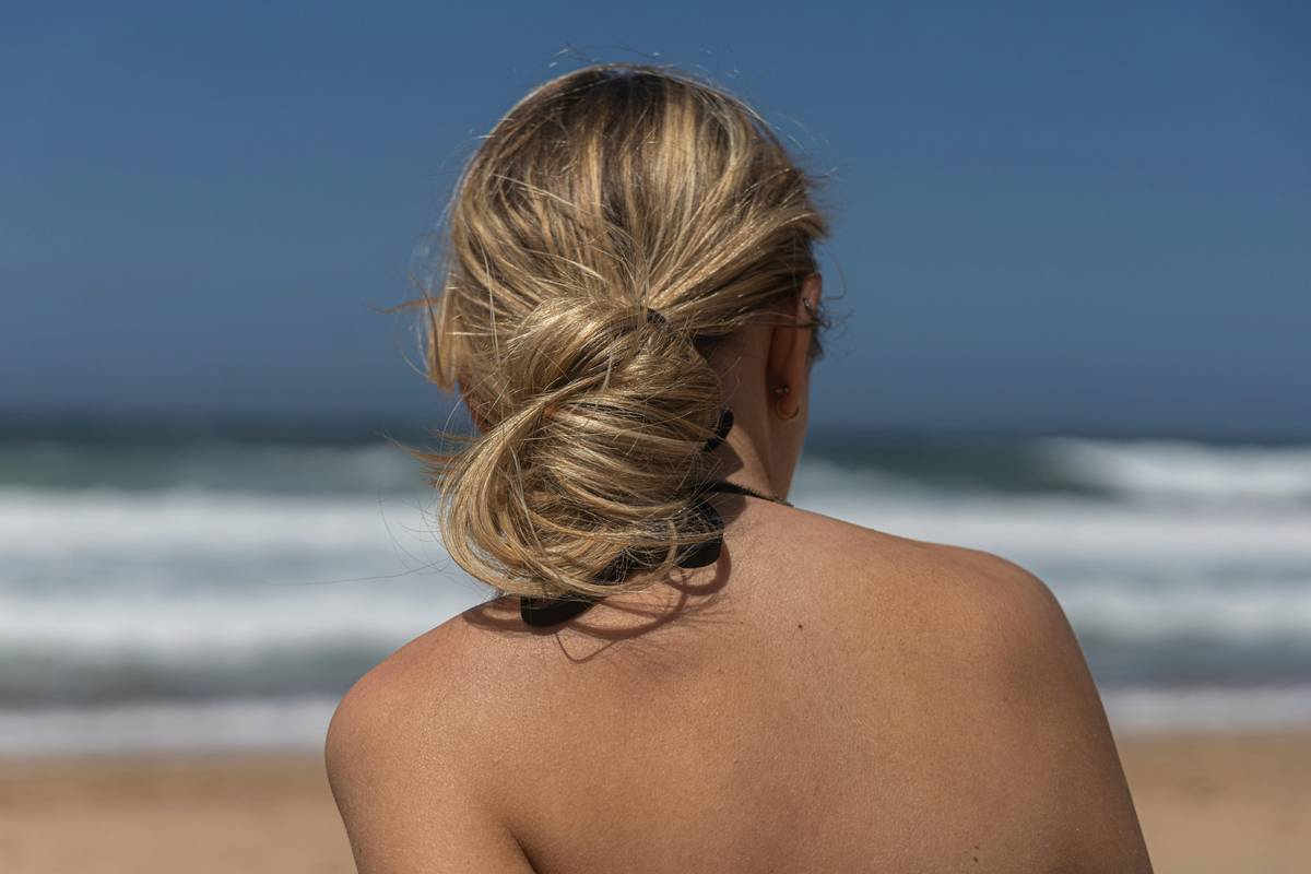 easy hair updos with decorative barrettes holding a low twisted bun on medium-length brown hair